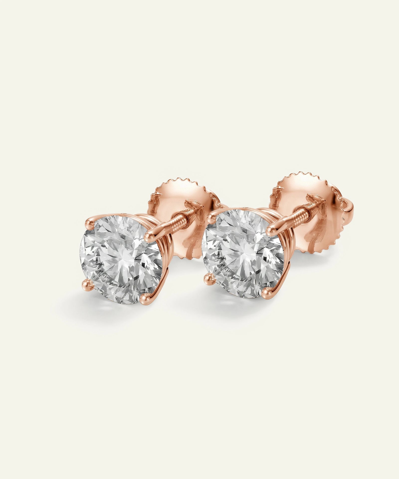 Rose gold stud earrings with clear gemstones on a light gray background