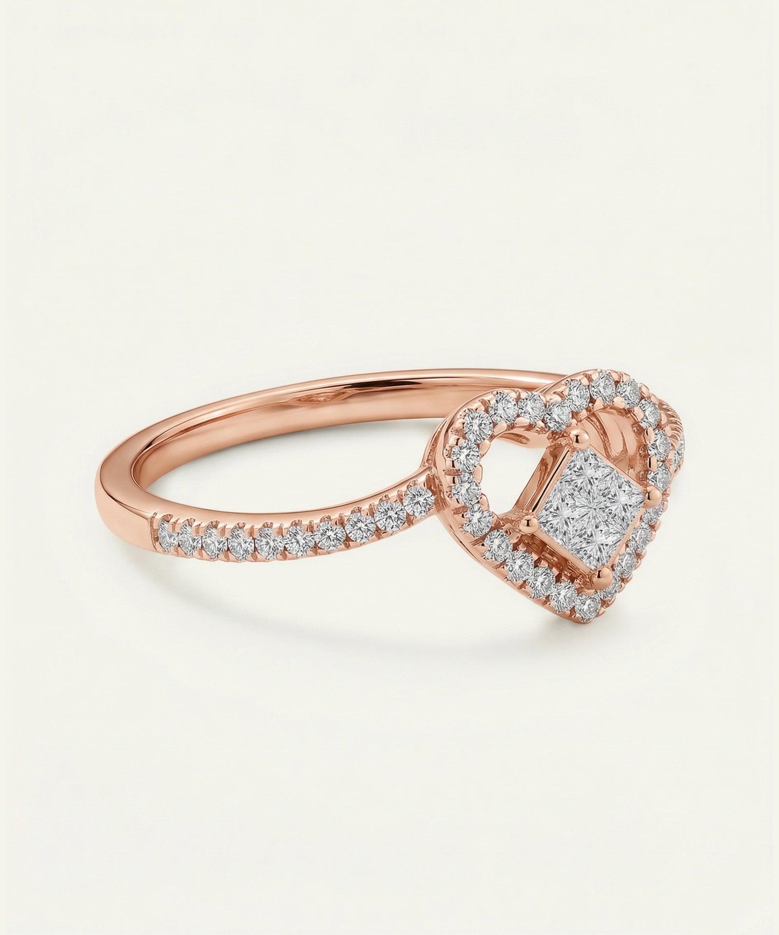 Rose gold ring with heart-shaped diamond design on a light beige background