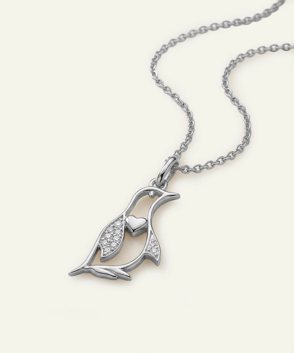 Silver penguin pendant necklace on a white background