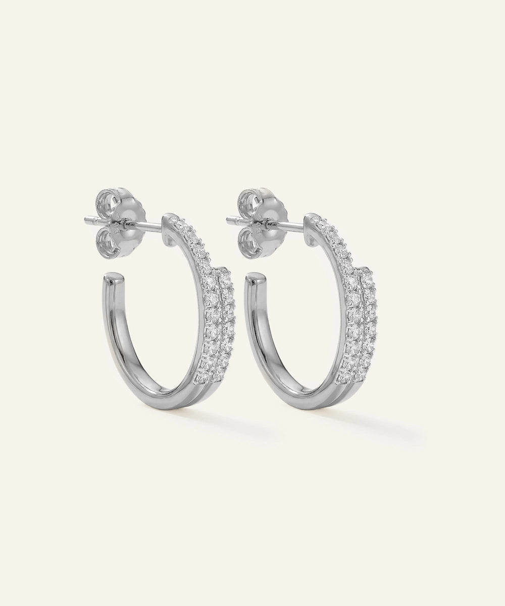 Silver hoop earrings with embedded stones on a white background