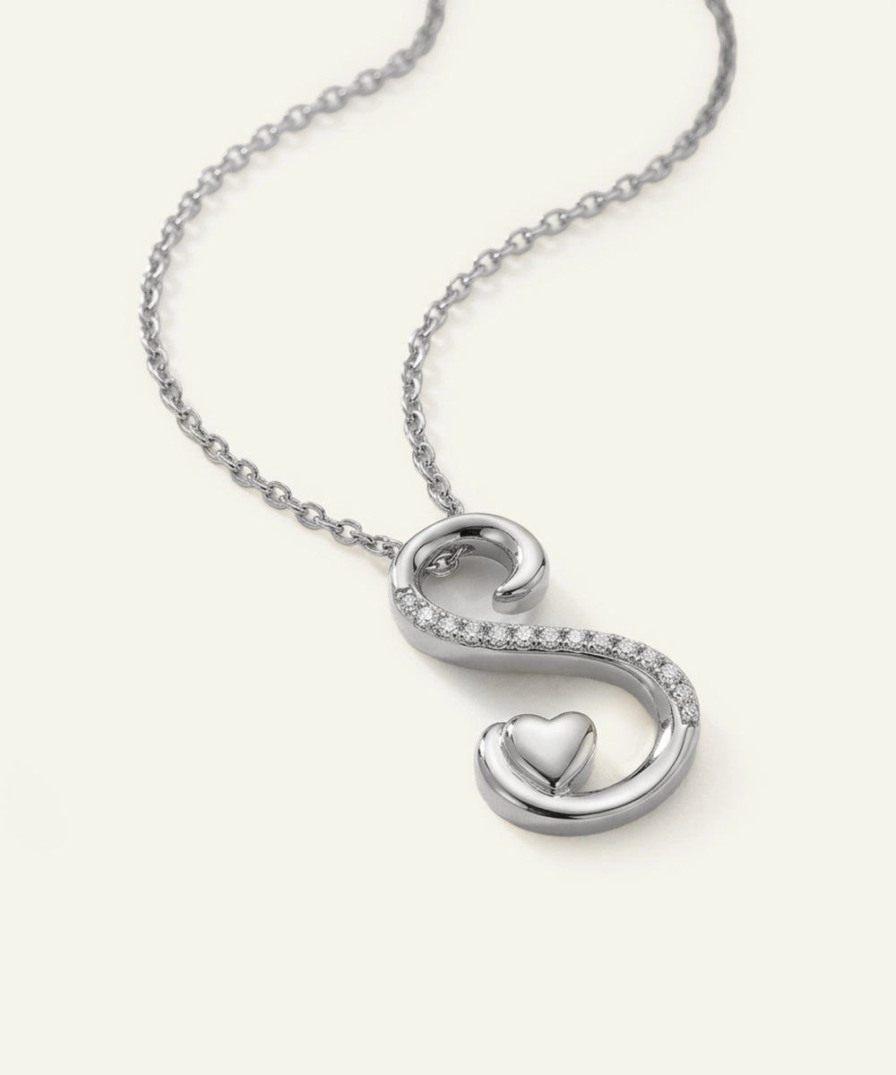 Silver necklace with a heart-shaped pendant on a white background