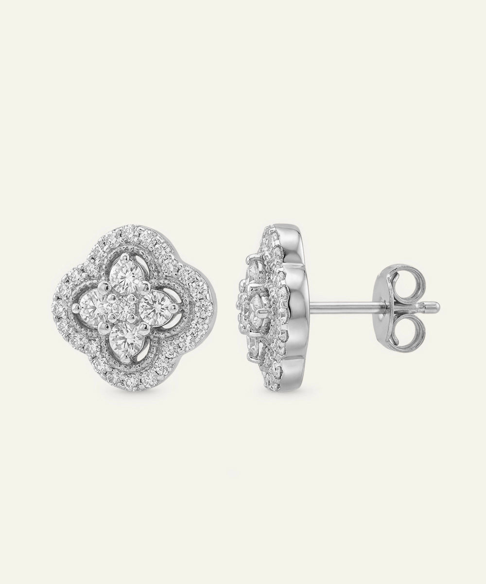 Pair of silver earrings with floral design on a light gray background