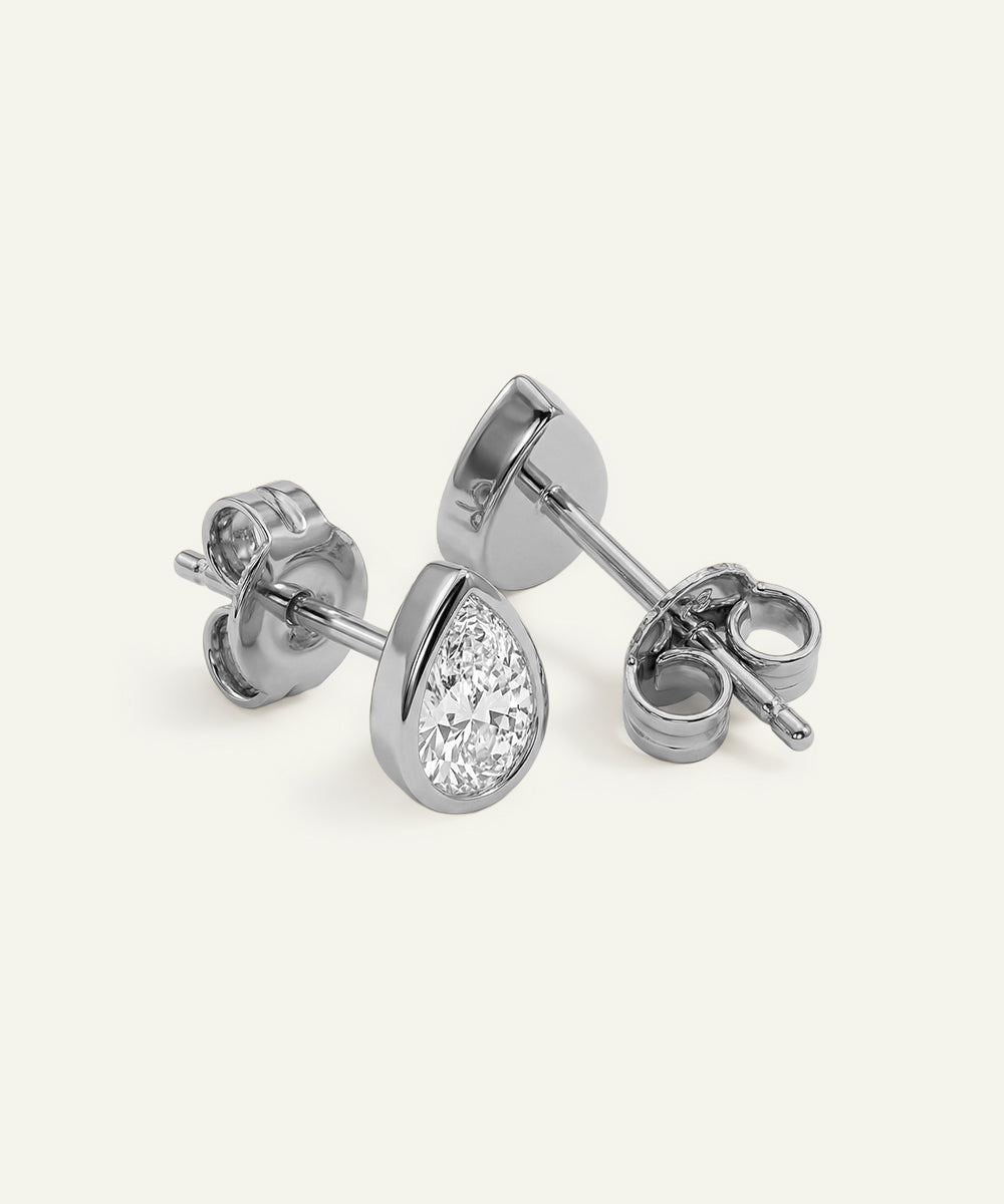 Pair of silver teardrop-shaped stud earrings on a white background