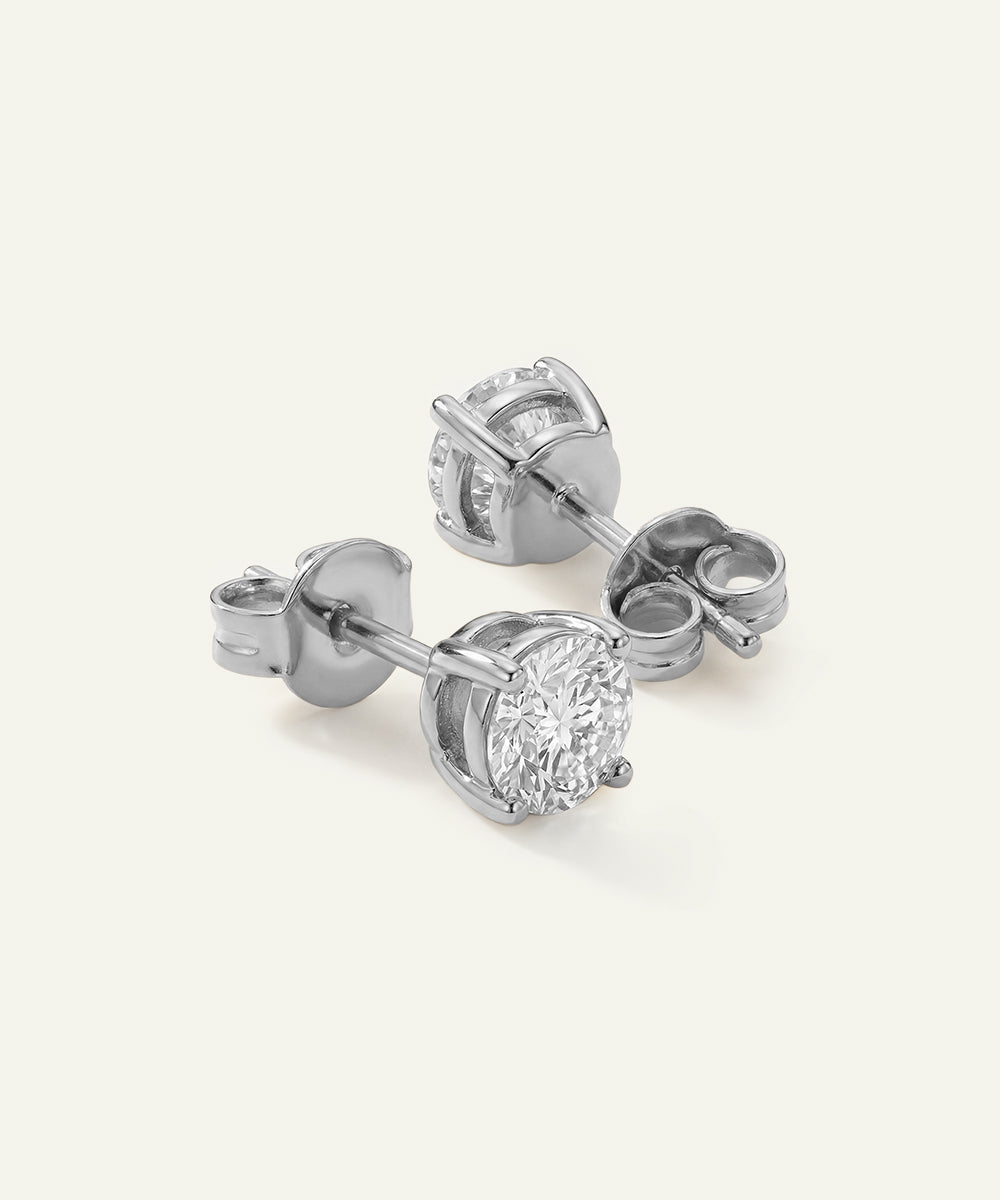 Pair of silver diamond stud earrings on a light gray background