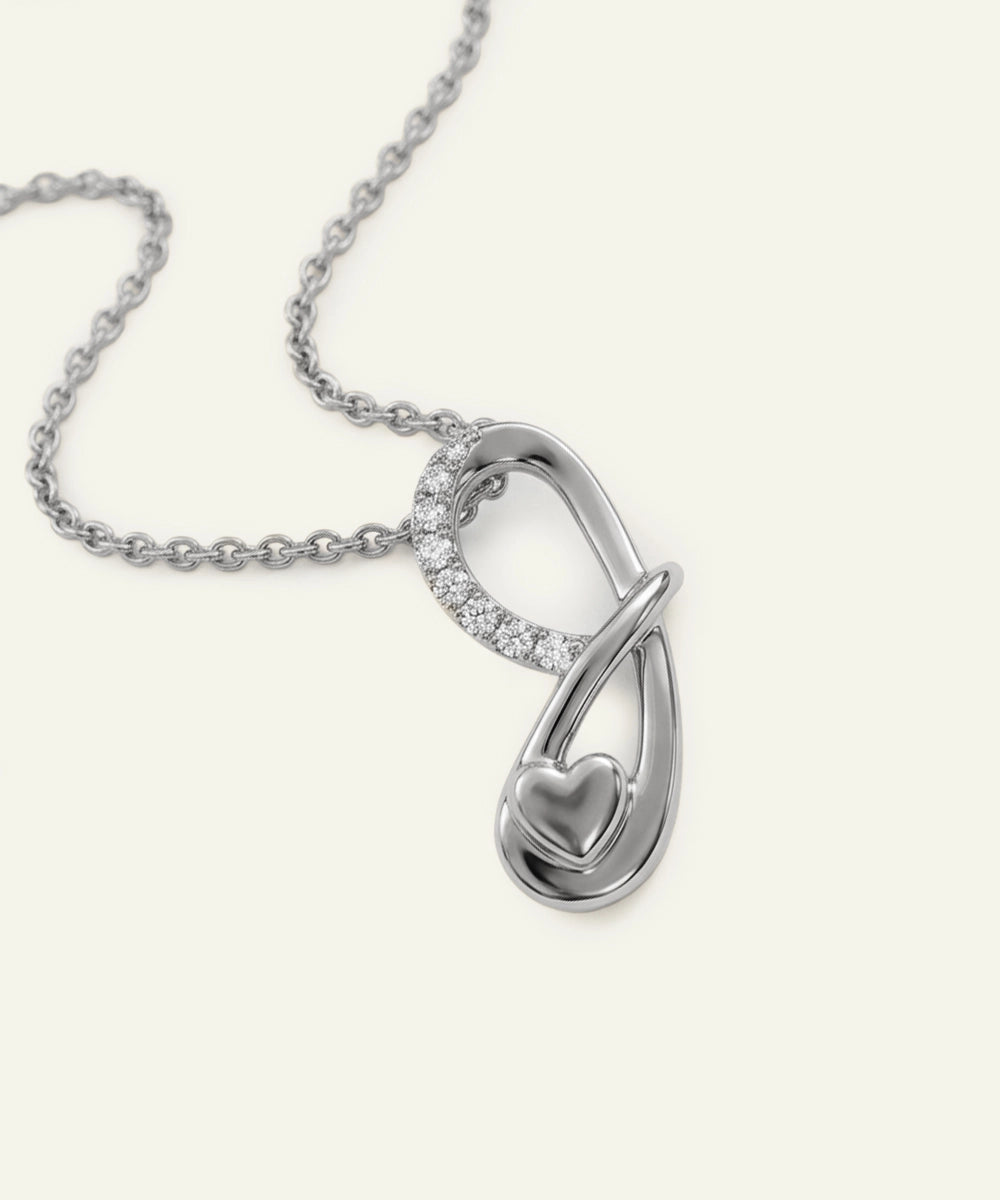 Silver necklace with a heart-shaped pendant on a white background