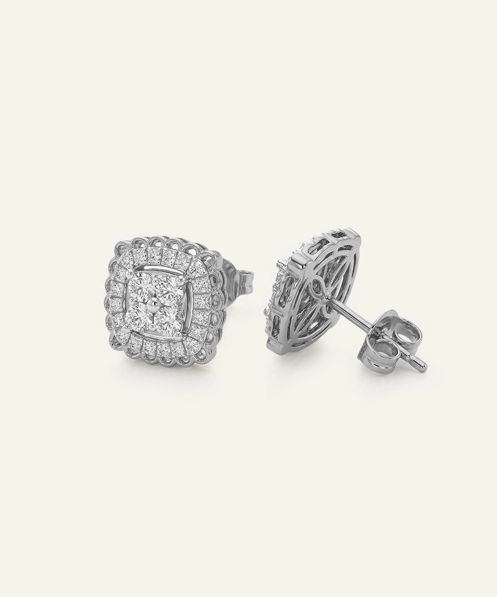 Pair of silver earrings with diamond-like stones on a white background