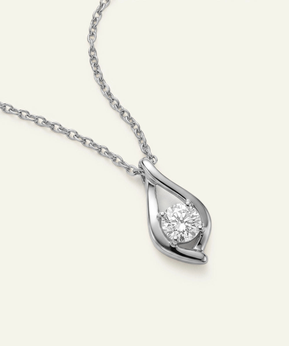 Silver teardrop-shaped pendant with a diamond on a white background