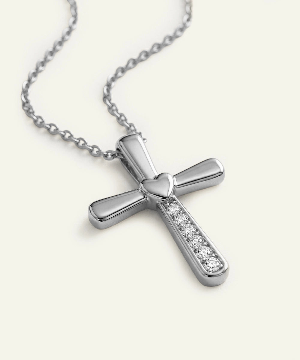 Silver cross pendant necklace on a white background