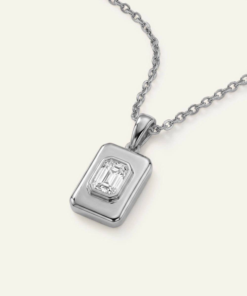 Silver pendant with a rectangular gemstone on a white background