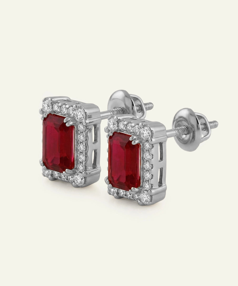 Pair of silver earrings with red gemstones on a white background