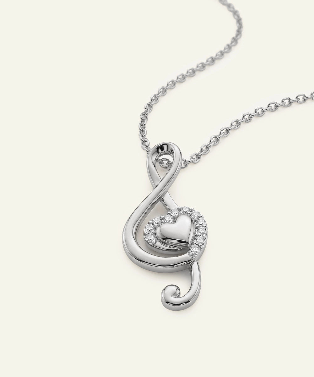 Silver necklace with a treble clef pendant on a white background