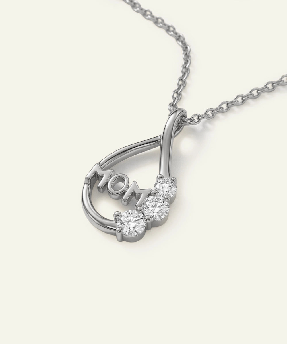 Silver necklace with 'MOM' pendant on a white background