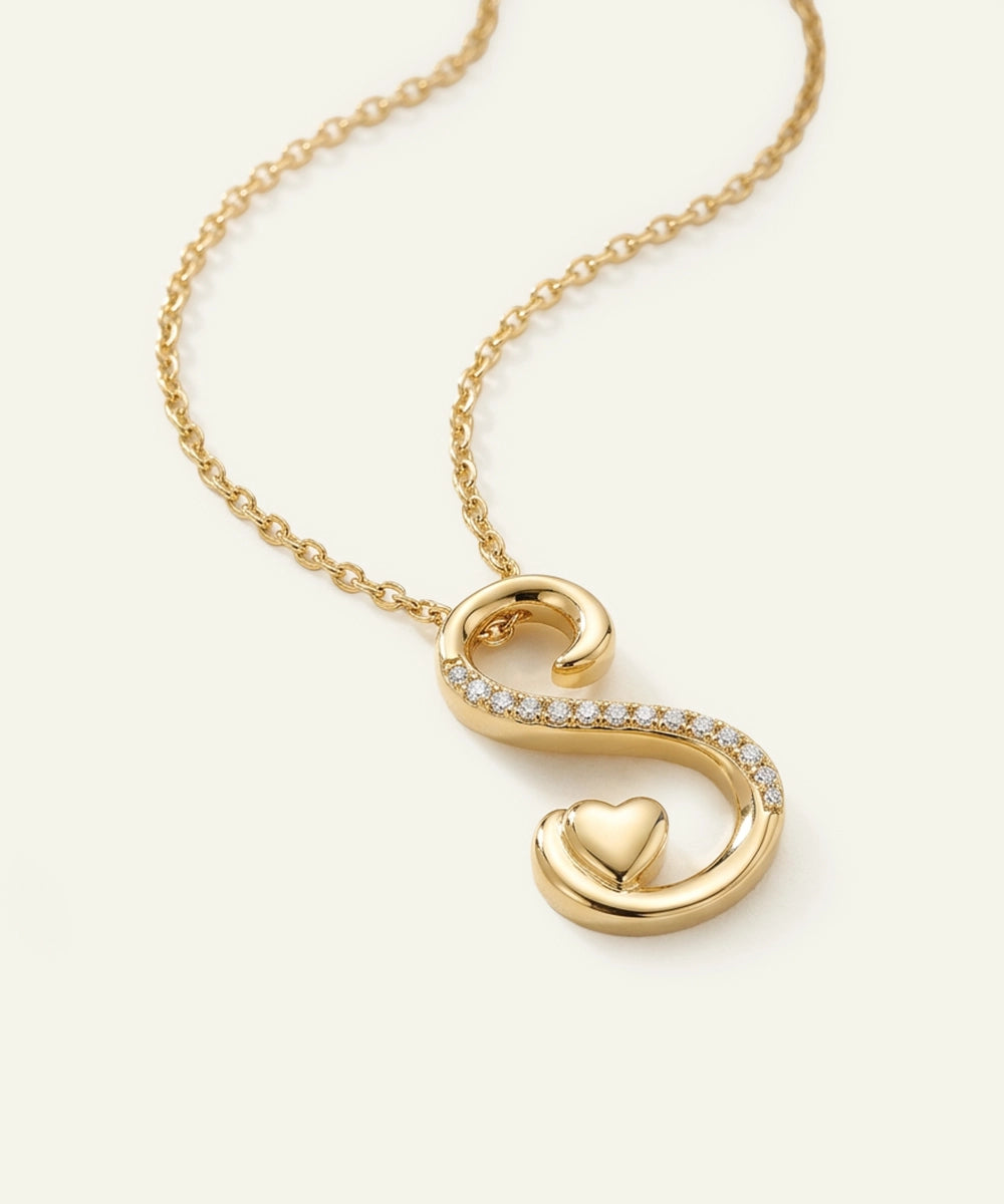 Gold necklace with a heart-shaped pendant on a white background