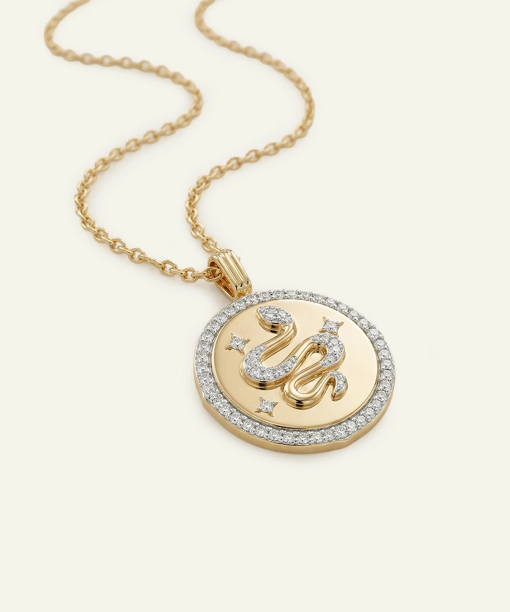 Gold necklace with a circular pendant featuring Arabic calligraphy on a white background
