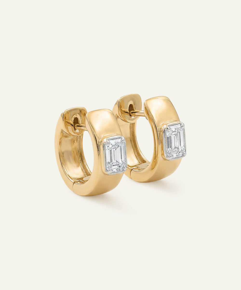Gold hoop earrings with diamond accents on a light background