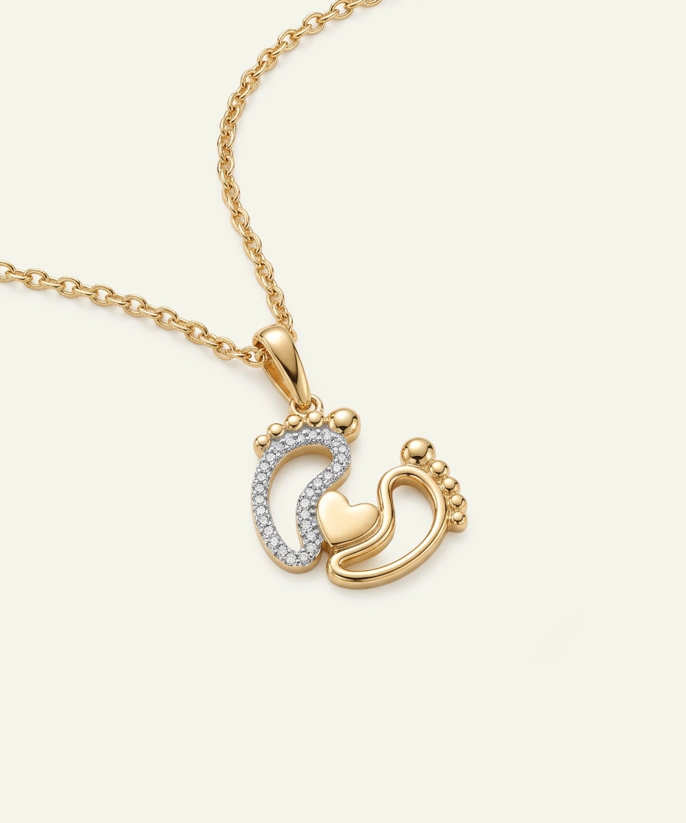 Gold necklace with a pendant featuring interlocking hearts on a light beige background