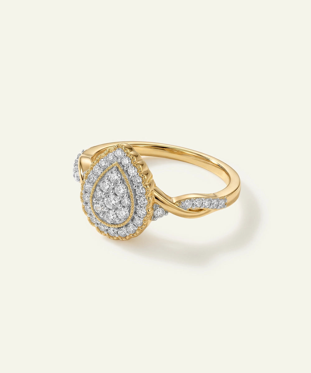 Gold ring with a teardrop-shaped diamond design on a light background