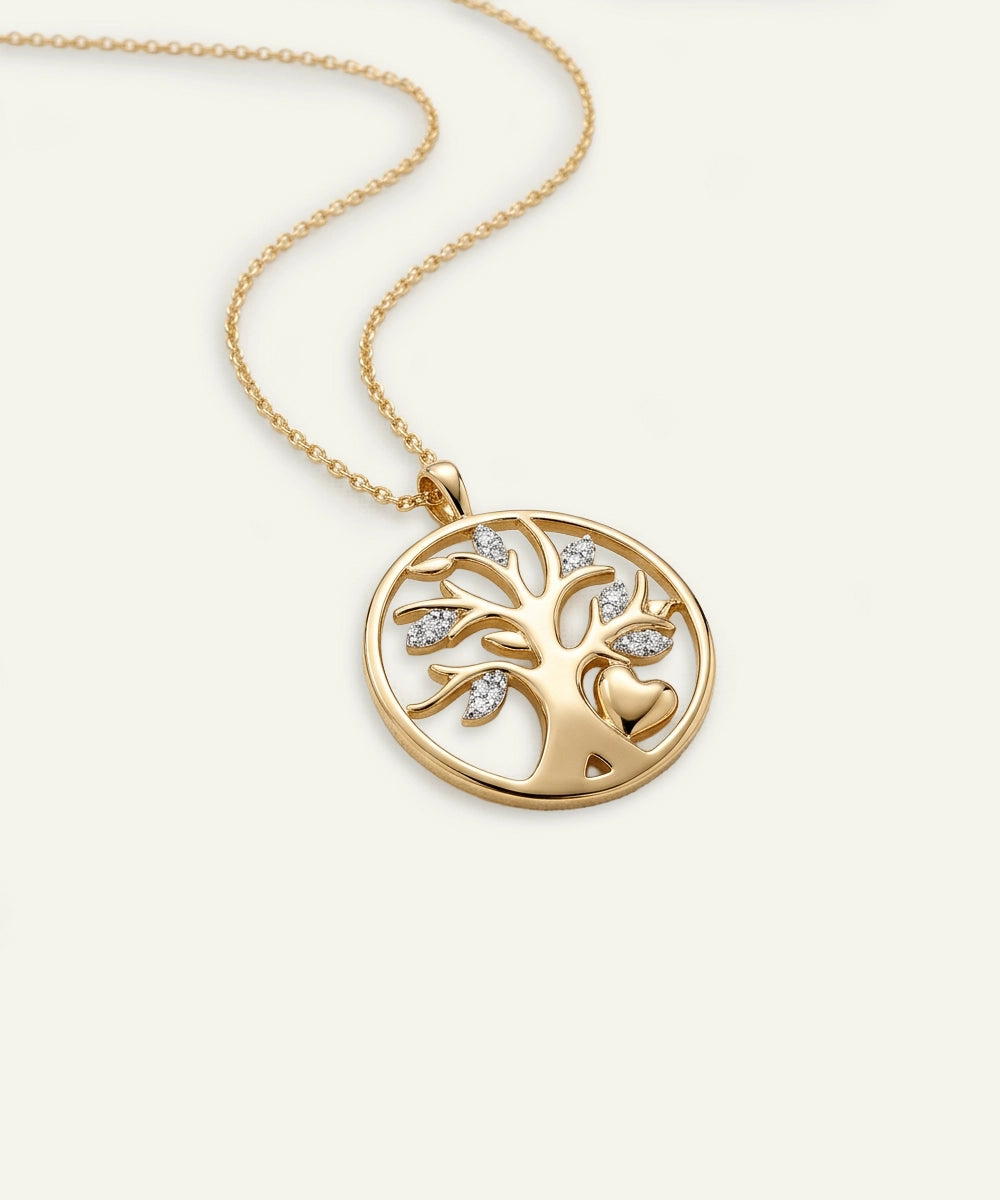 Gold necklace with a tree of life pendant on a light beige background
