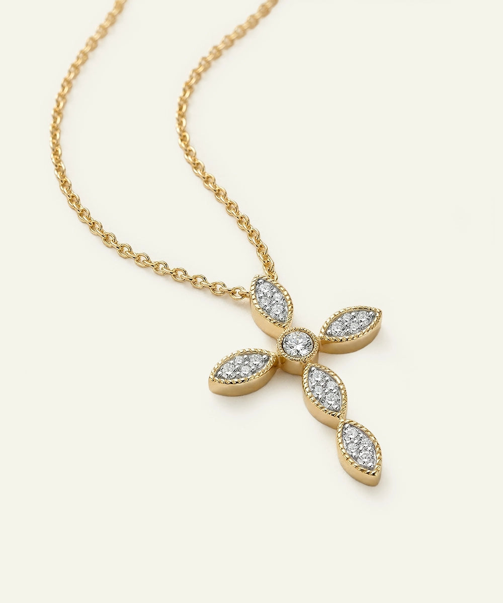 Gold cross necklace with diamond accents on a white background