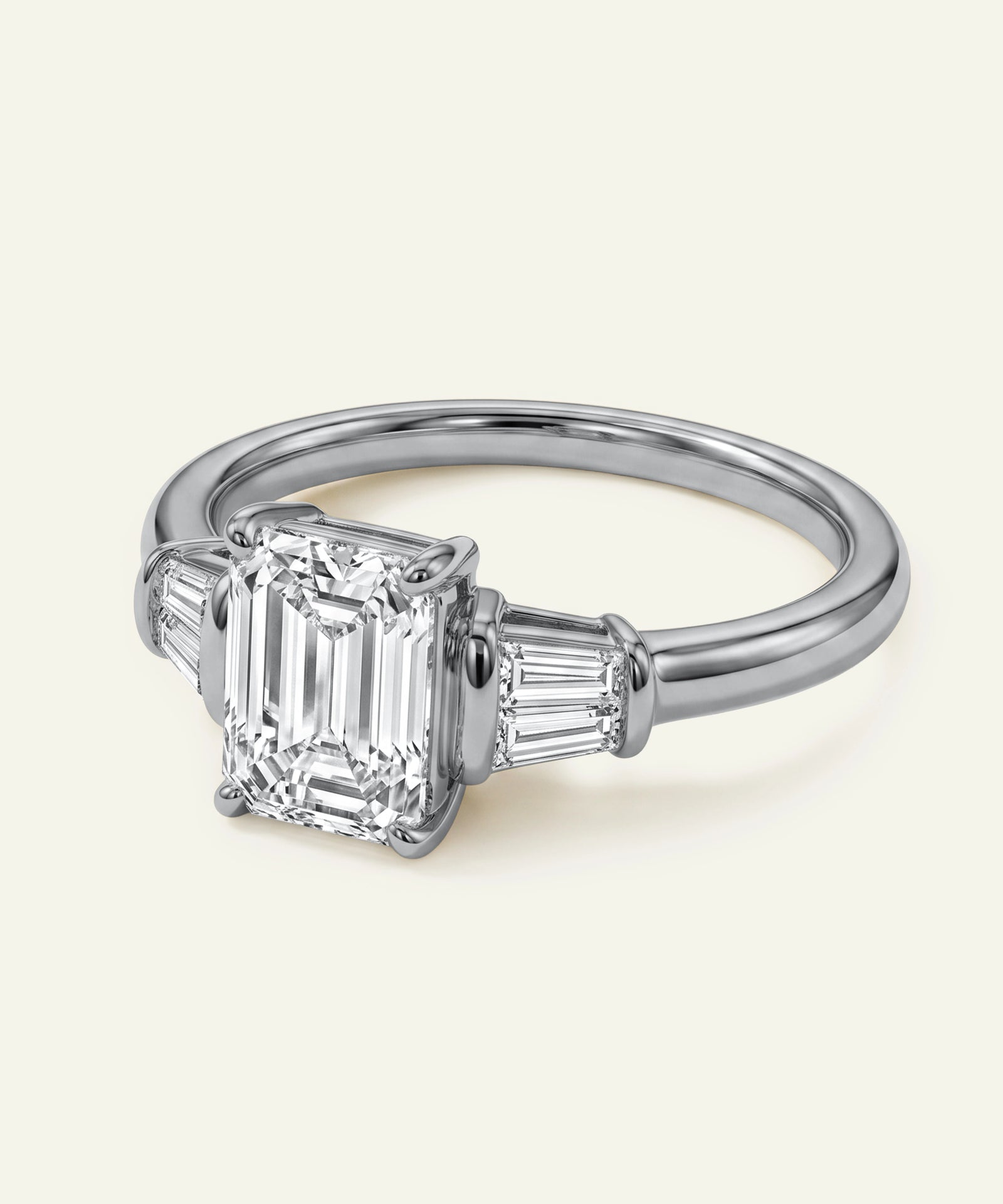 Diamond ring with emerald-cut gemstones on a white background