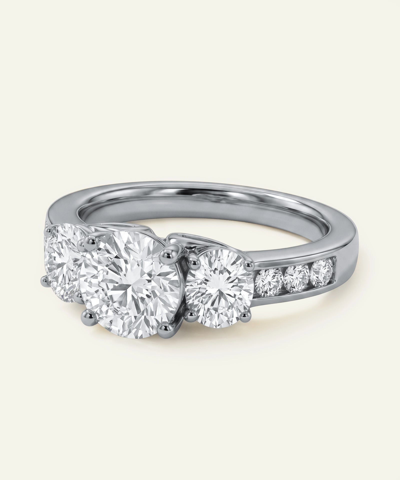 Silver ring with three diamond stones on a light beige background