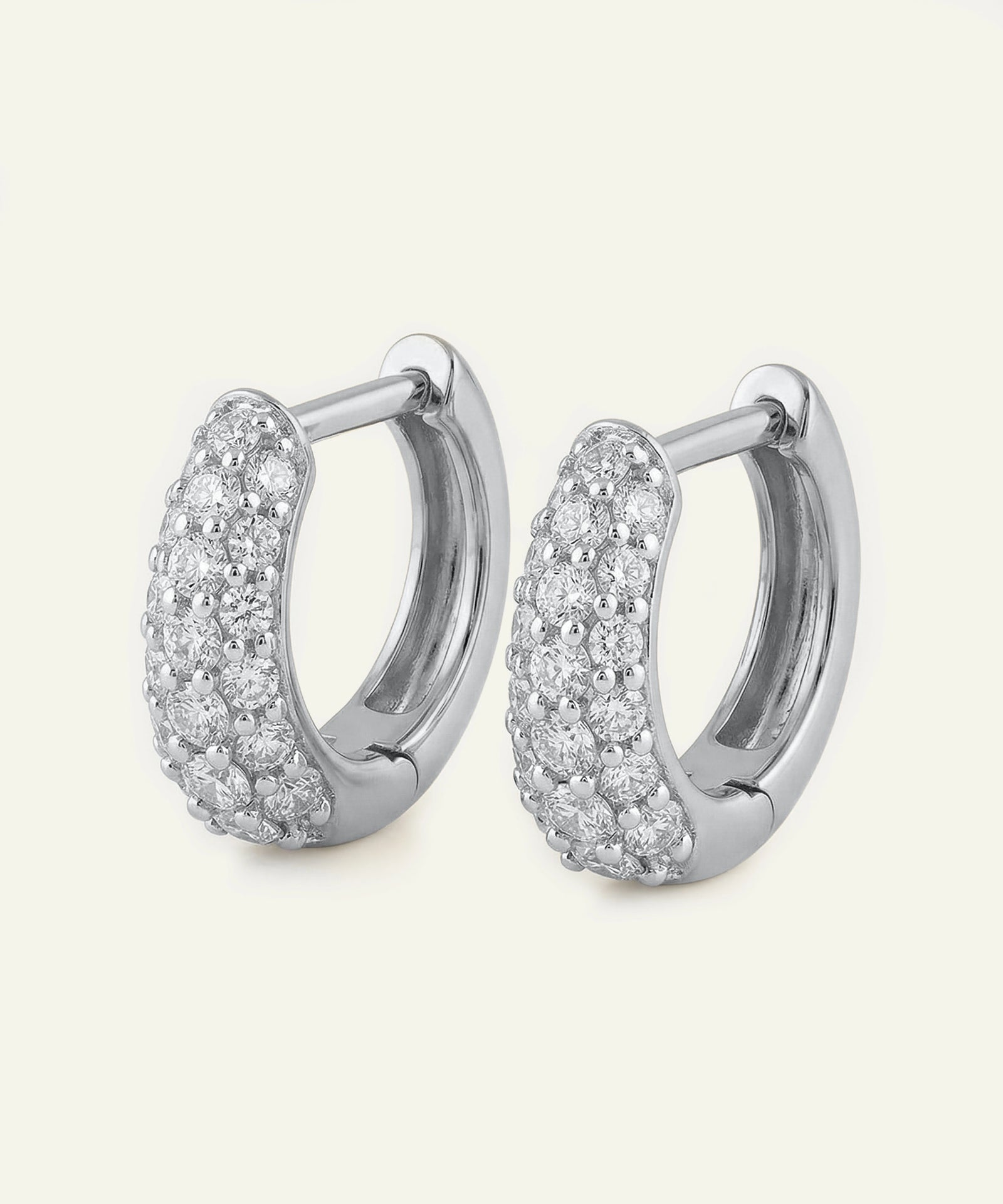 Pair of silver hoop earrings with clear gemstones on a white background