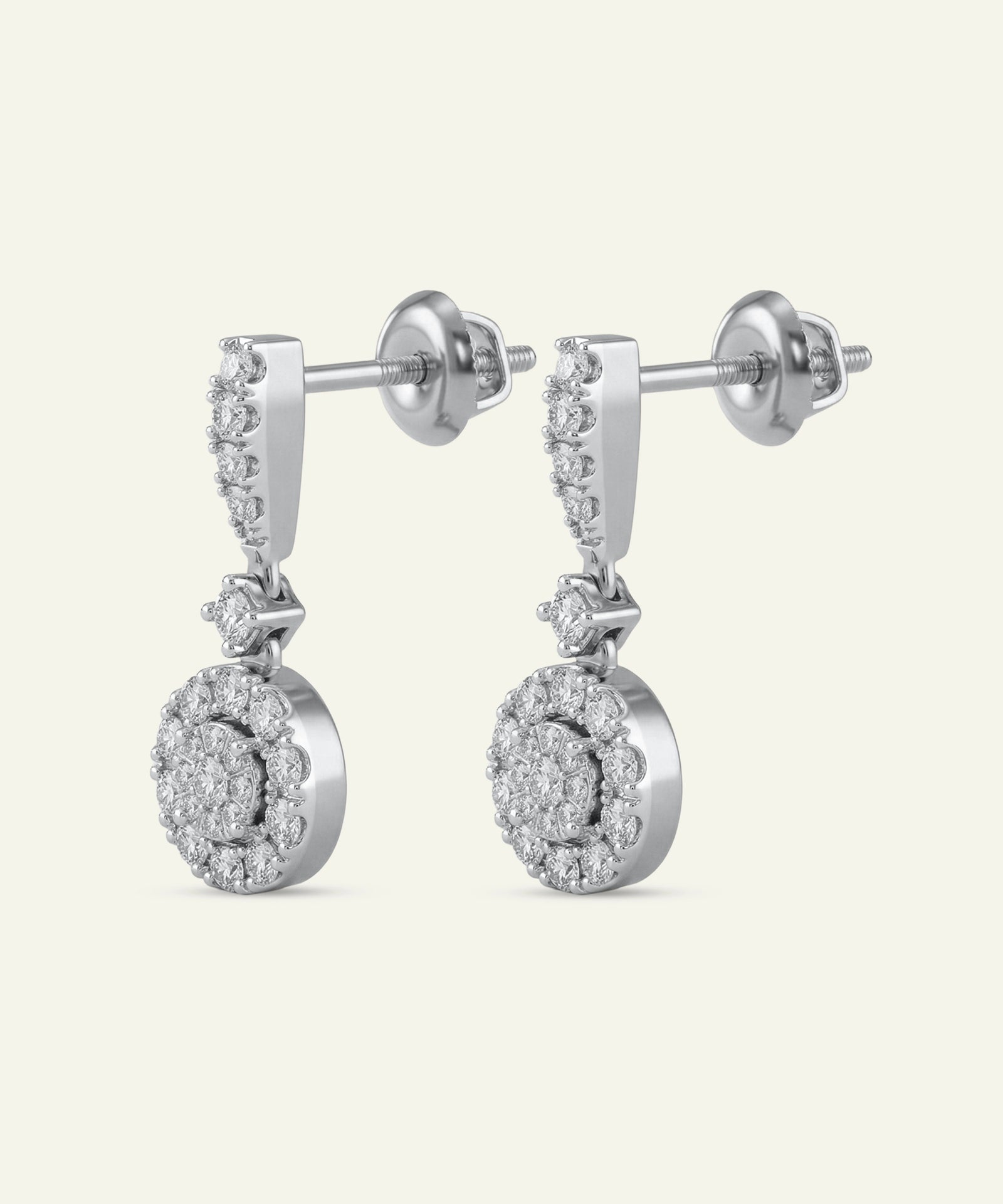 Pair of silver earrings with diamond-like stones on a white background