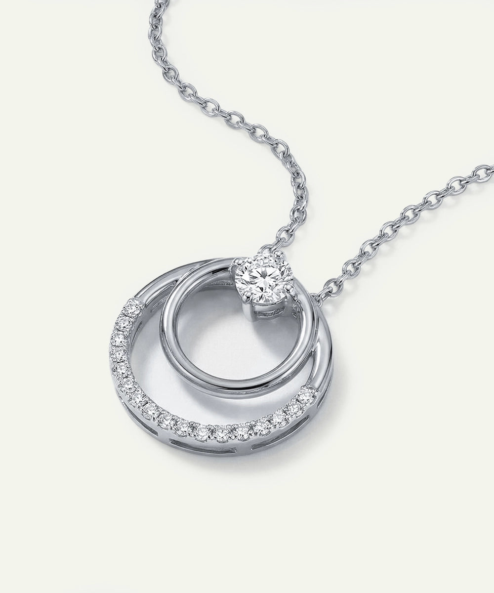 Silver necklace with a circular pendant on a white background