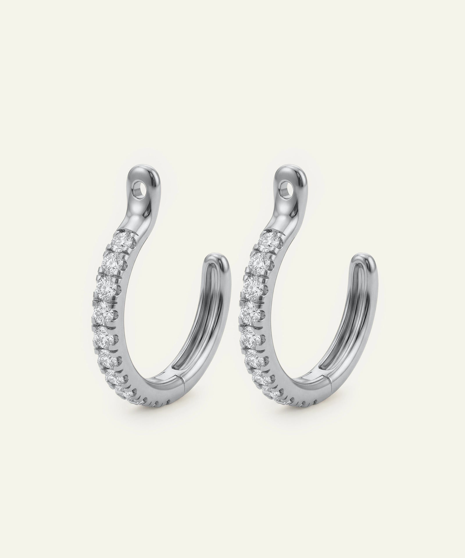 Pair of silver hoop earrings with embedded stones on a light gray background