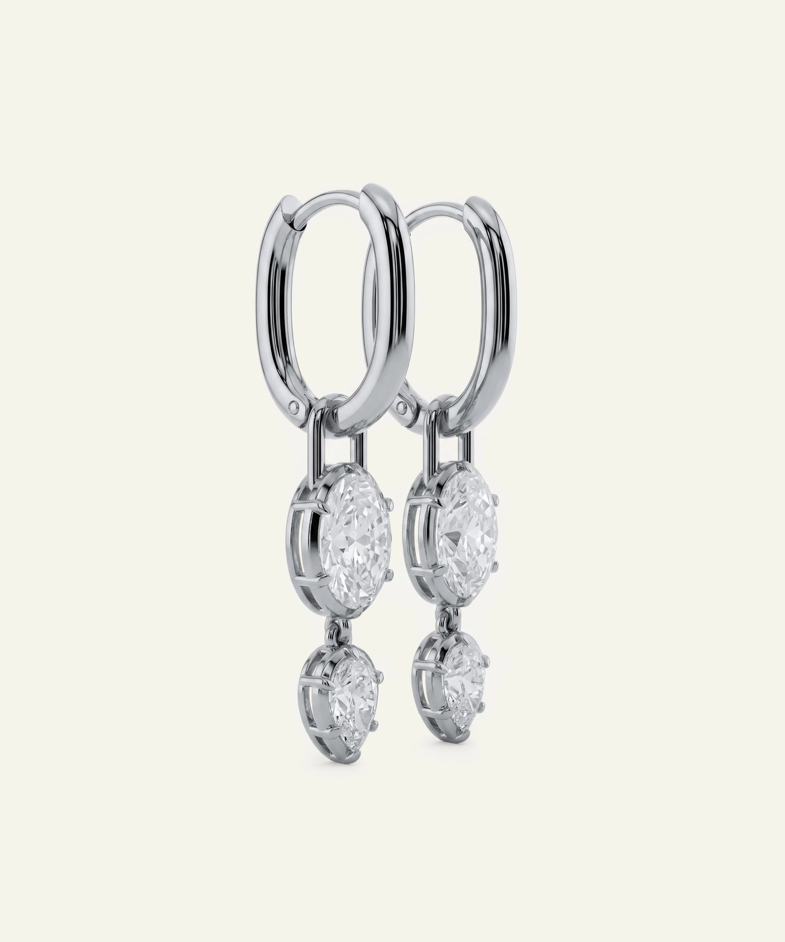 Silver hoop earrings with dangling diamond-like stones on a white background
