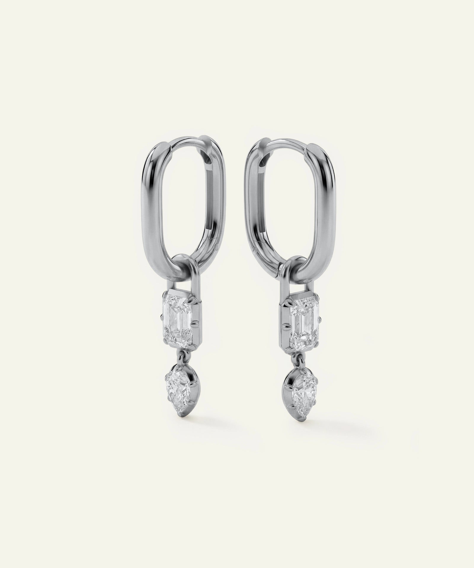 Pair of silver hoop earrings with diamond-like stones on a white background