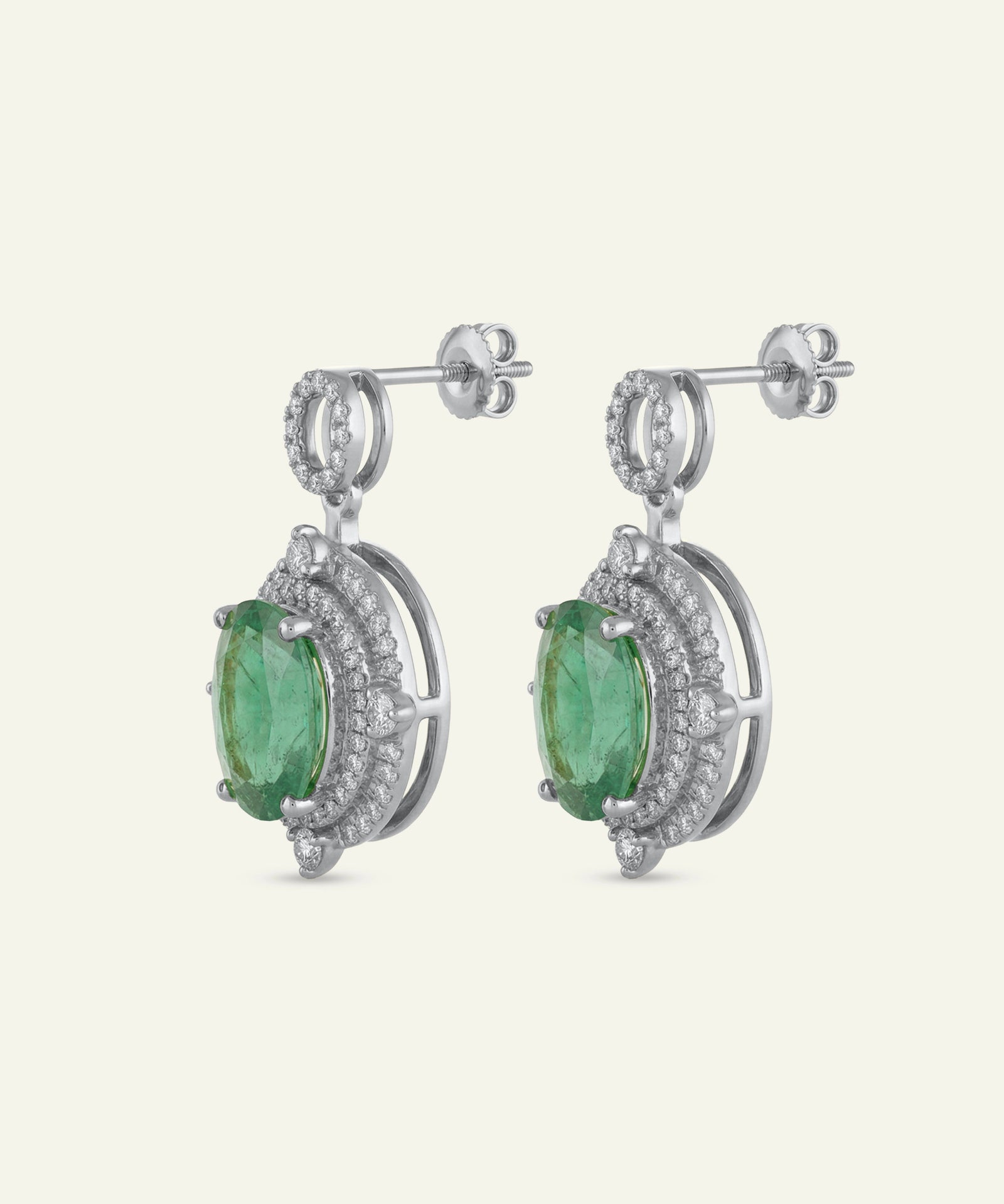 Pair of silver earrings with green gemstones on a white background