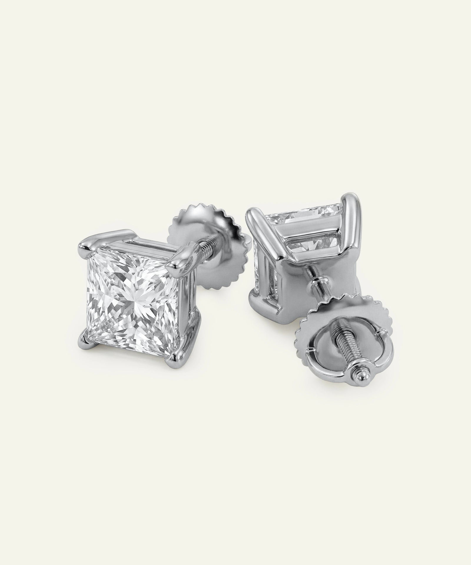 Pair of diamond stud earrings on a light gray background