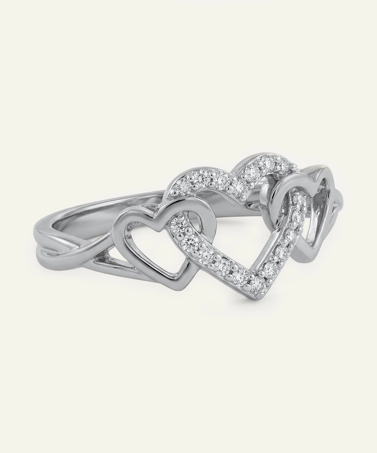 Silver heart-shaped ring with embedded diamonds on a white background