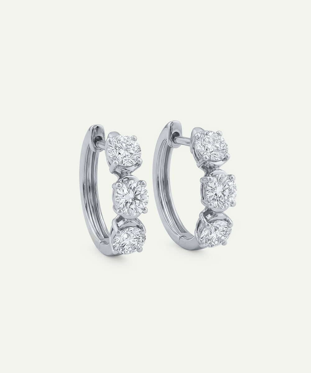 Pair of diamond hoop earrings on a light gray background