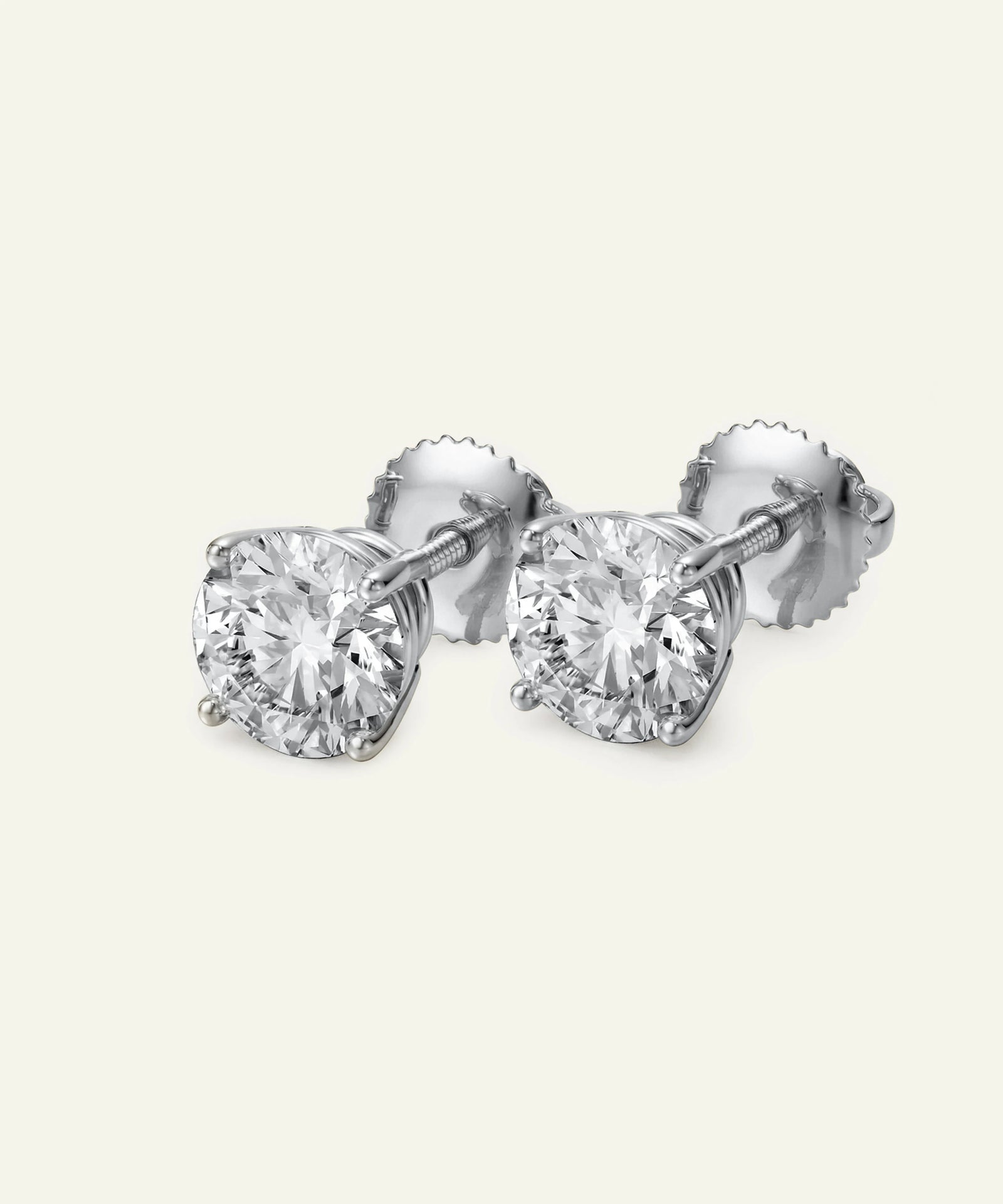 Pair of diamond stud earrings on a light gray background