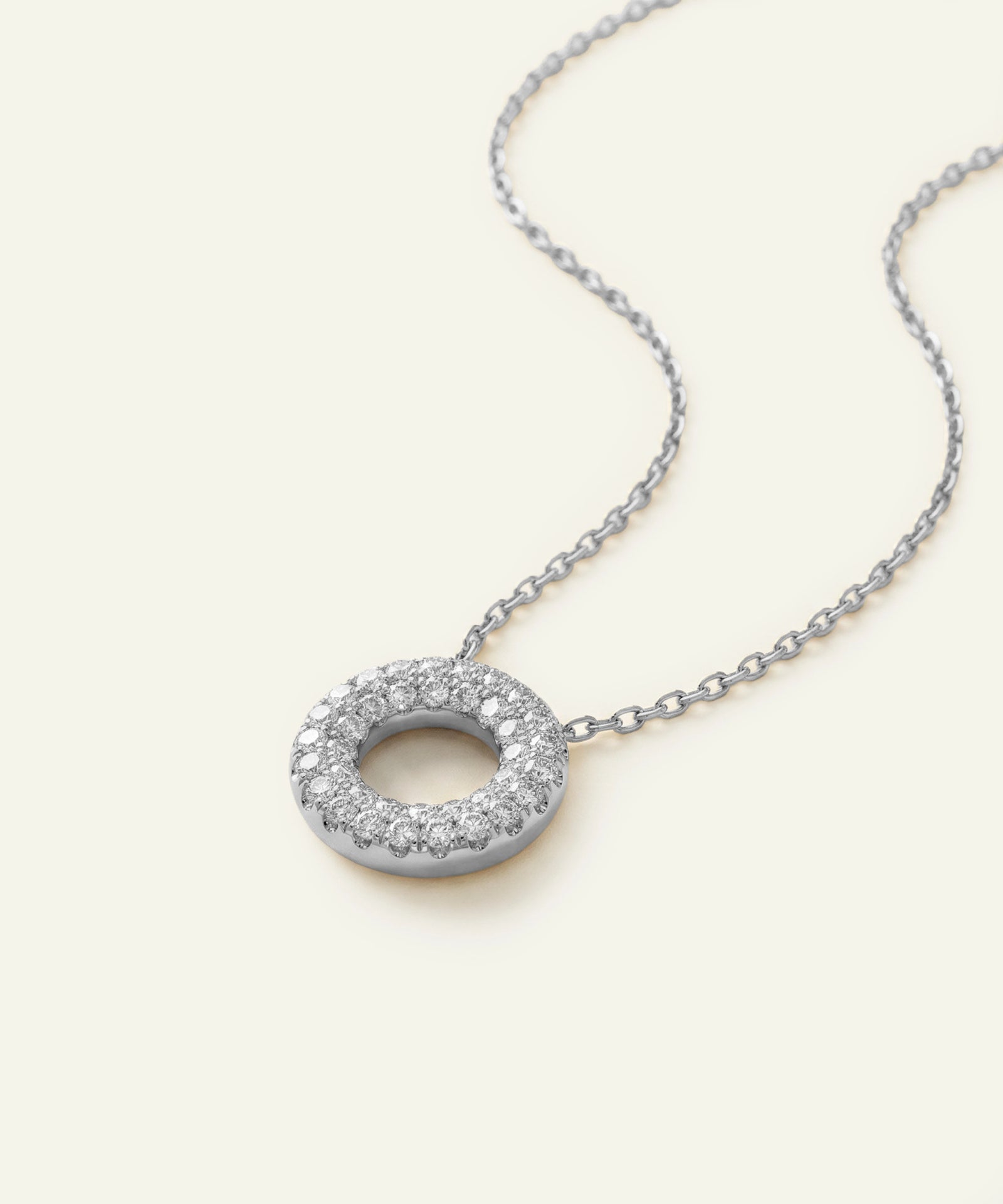 Silver necklace with a round pendant on a white background