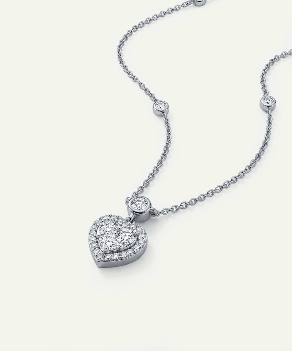 Heart-shaped diamond pendant on a chain against a white background