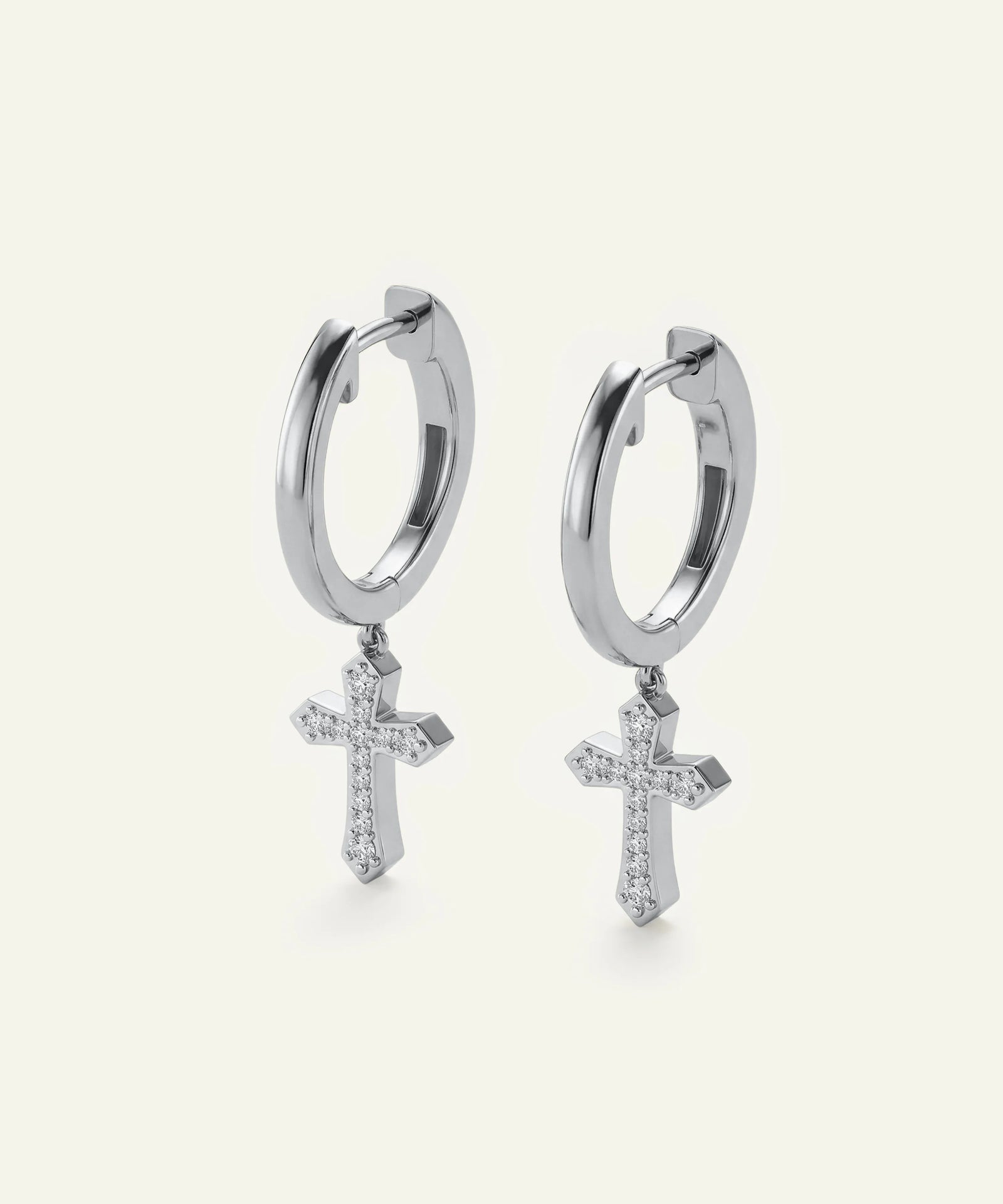 Silver hoop earrings with cross pendants on a white background