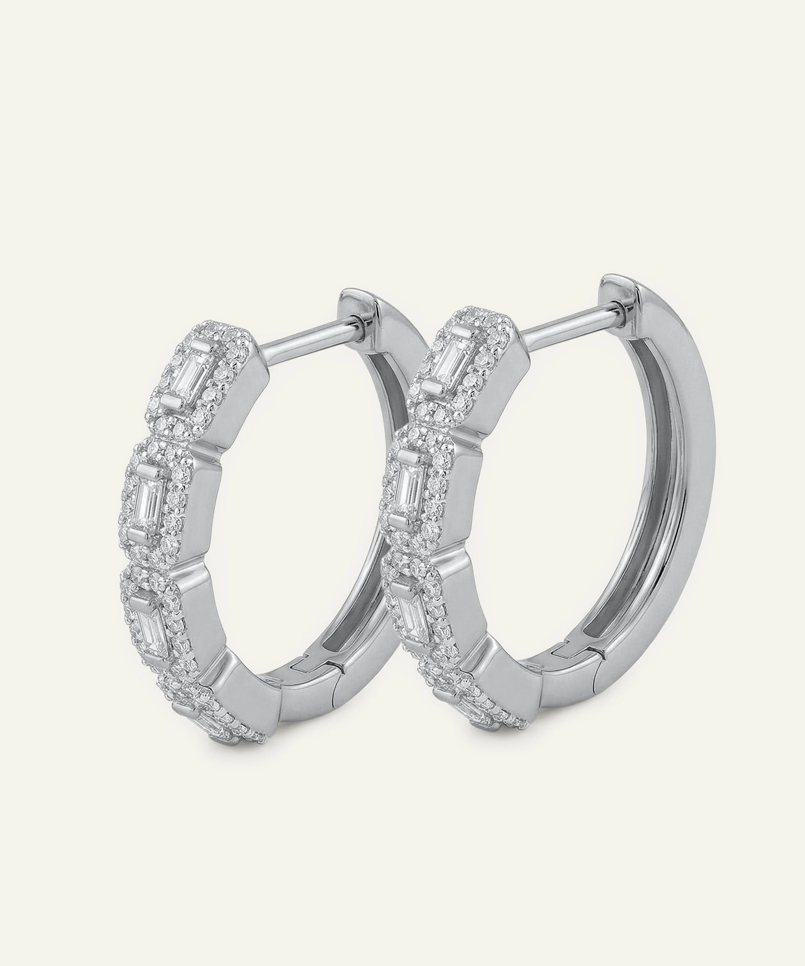 Silver hoop earrings with diamond accents on a light gray background