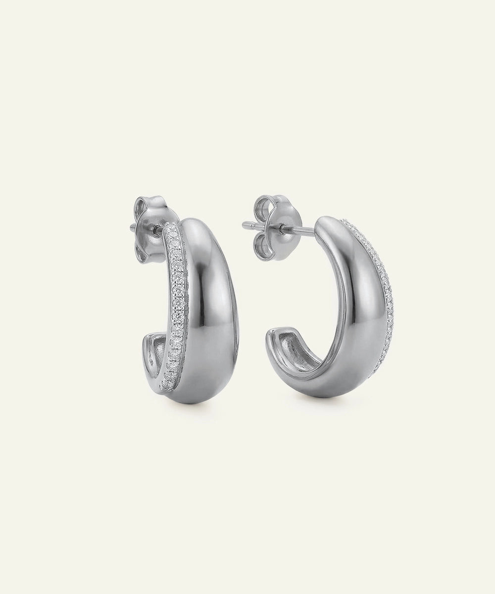 Pair of silver hoop earrings on a light gray background