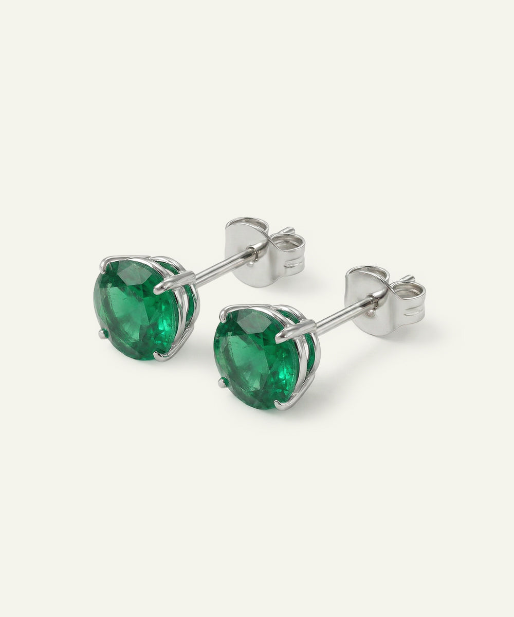 Pair of emerald stud earrings on a white background