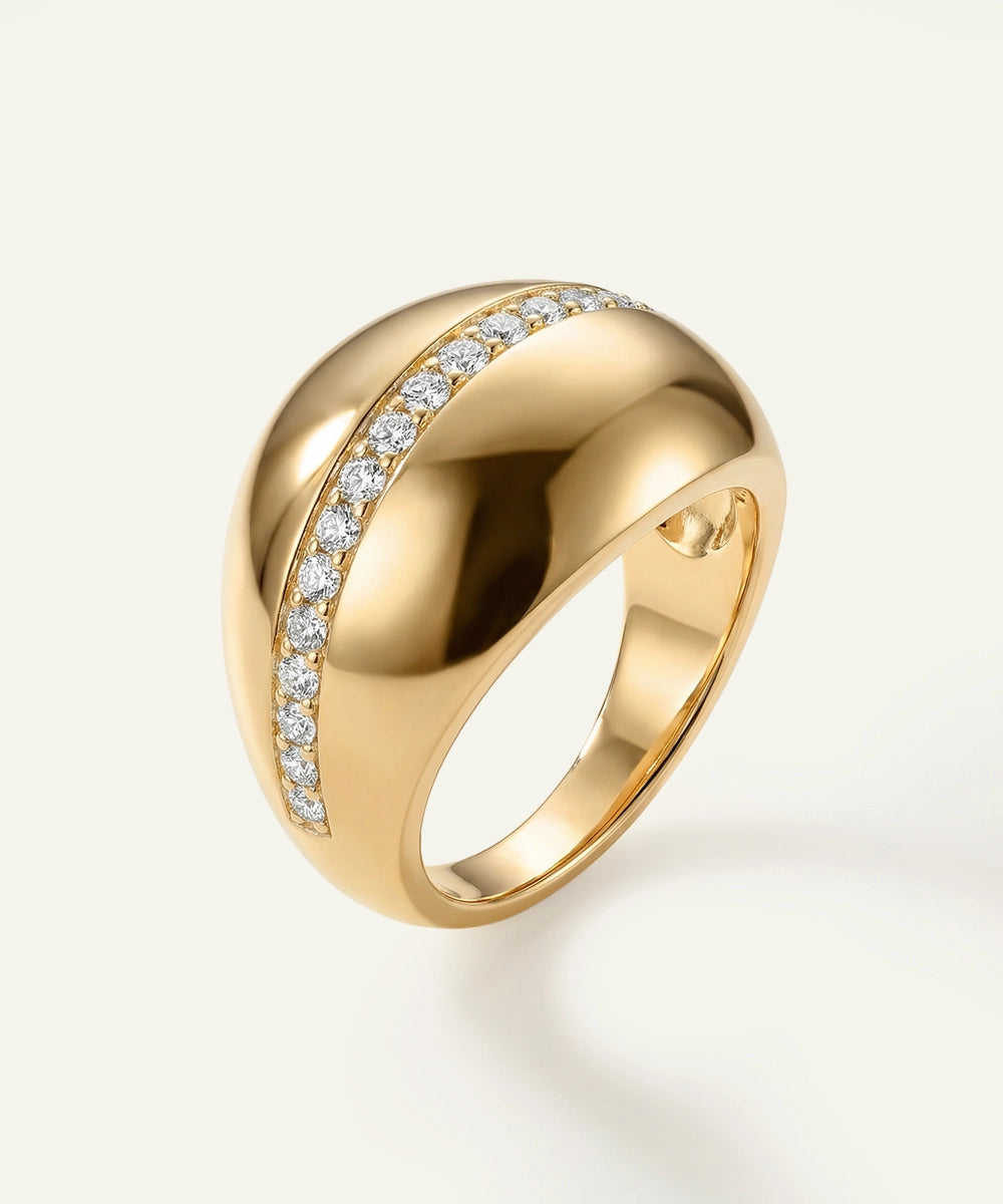 Gold ring with diamond accents on a light background