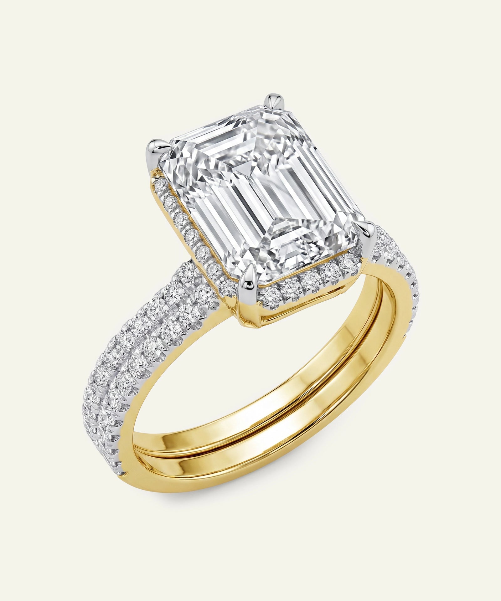 Gold ring with a large emerald-cut diamond and smaller diamonds on a white background