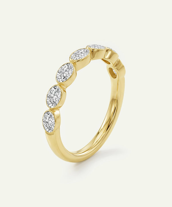 Gold ring with diamonds on a light beige background