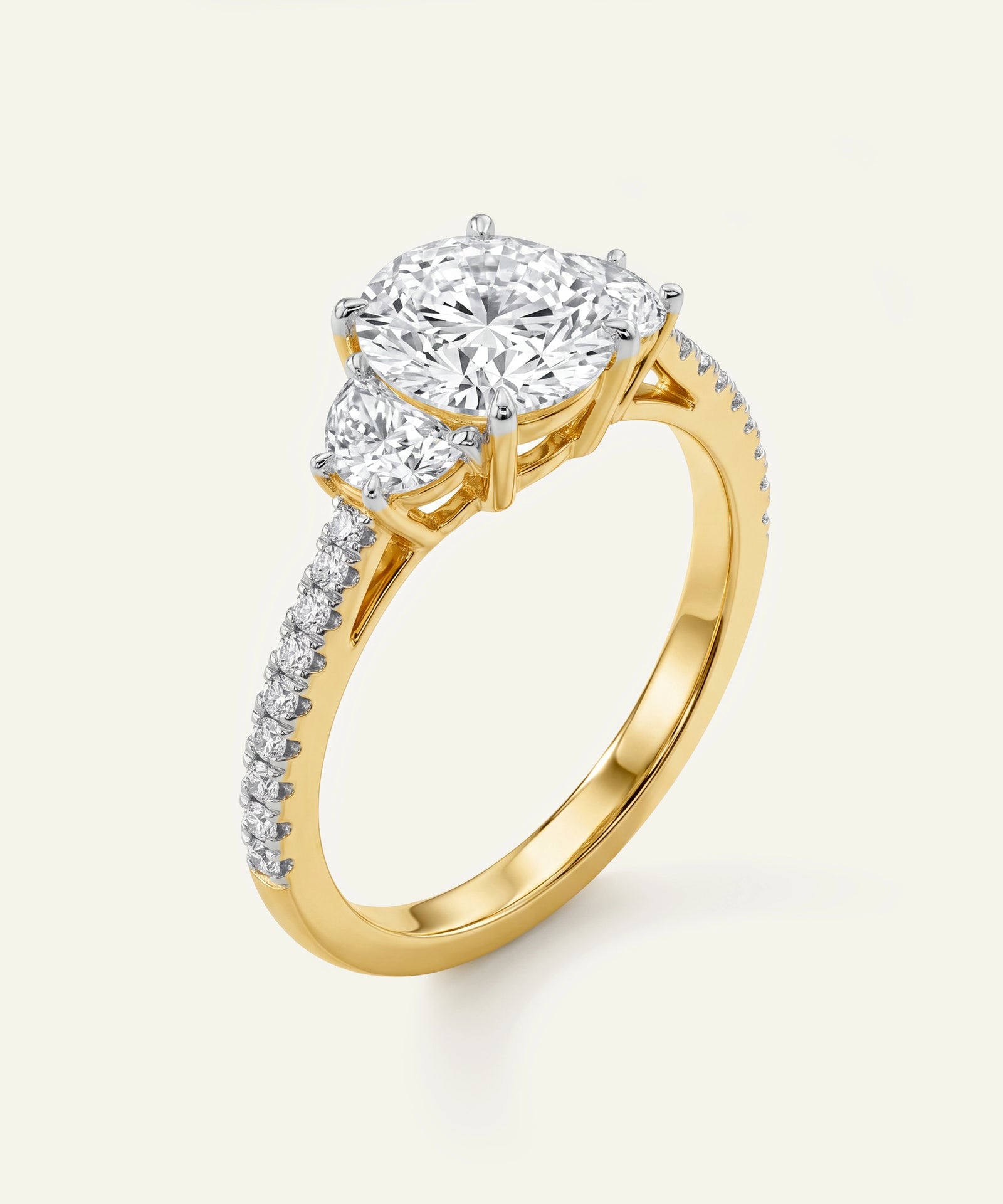 Gold ring with a large diamond and smaller diamonds on the band against a white background