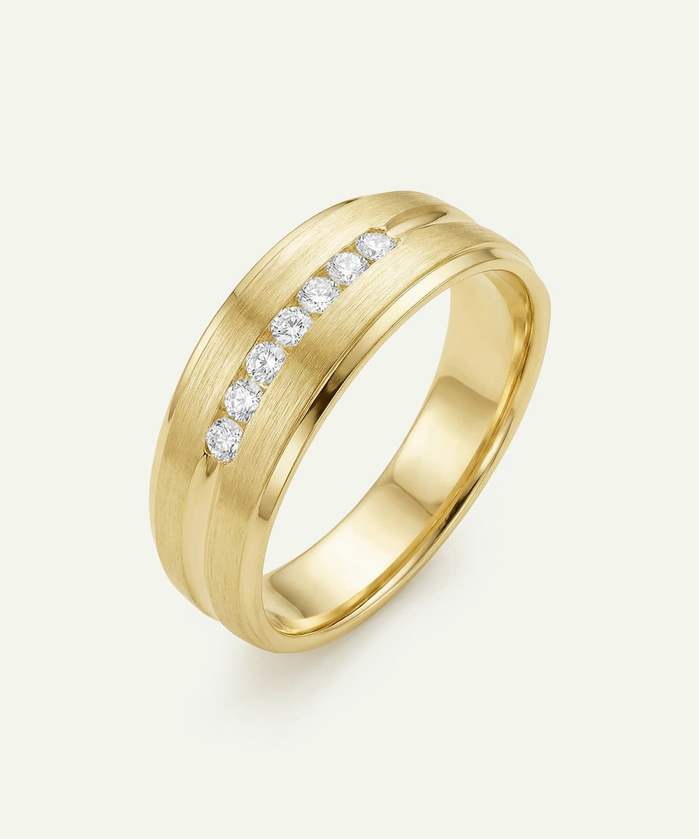 Gold ring with embedded diamonds on a light beige background