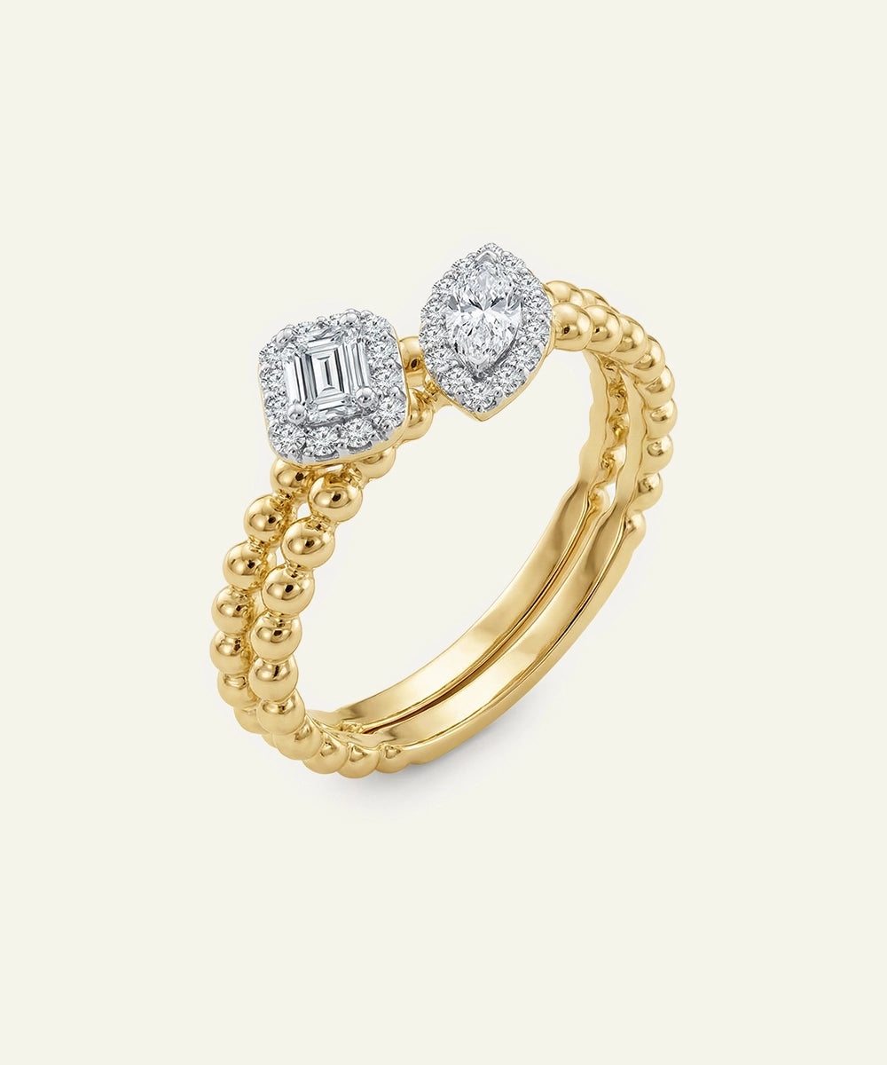 Gold ring with diamond accents on a light beige background