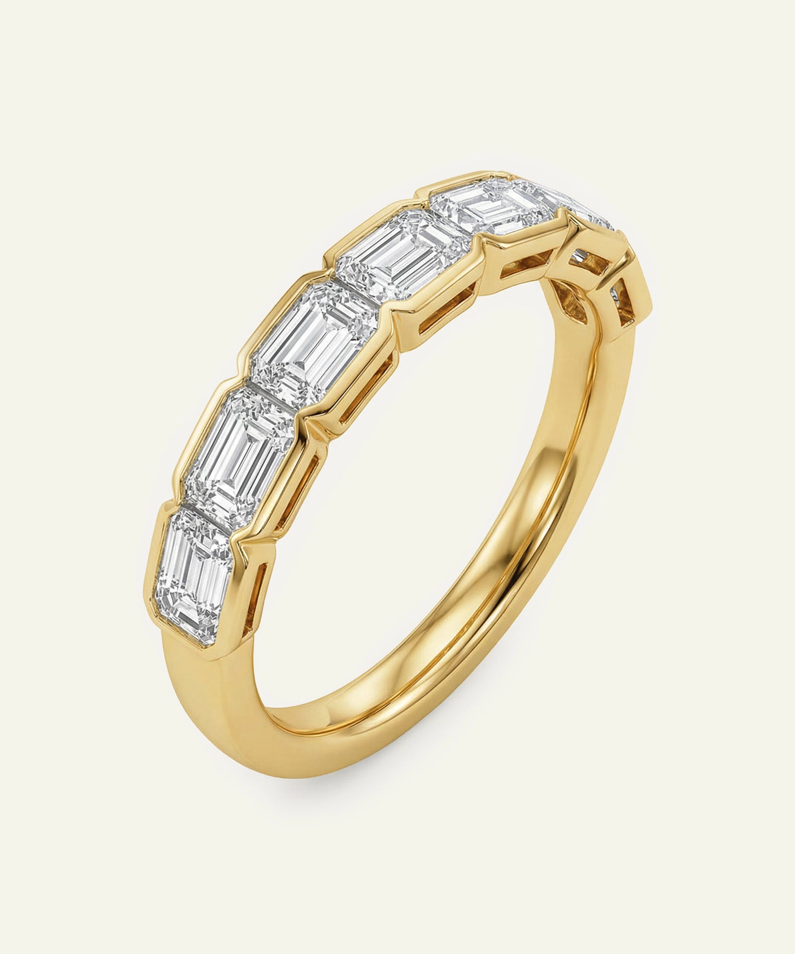 Gold ring with emerald-cut diamonds on a white background