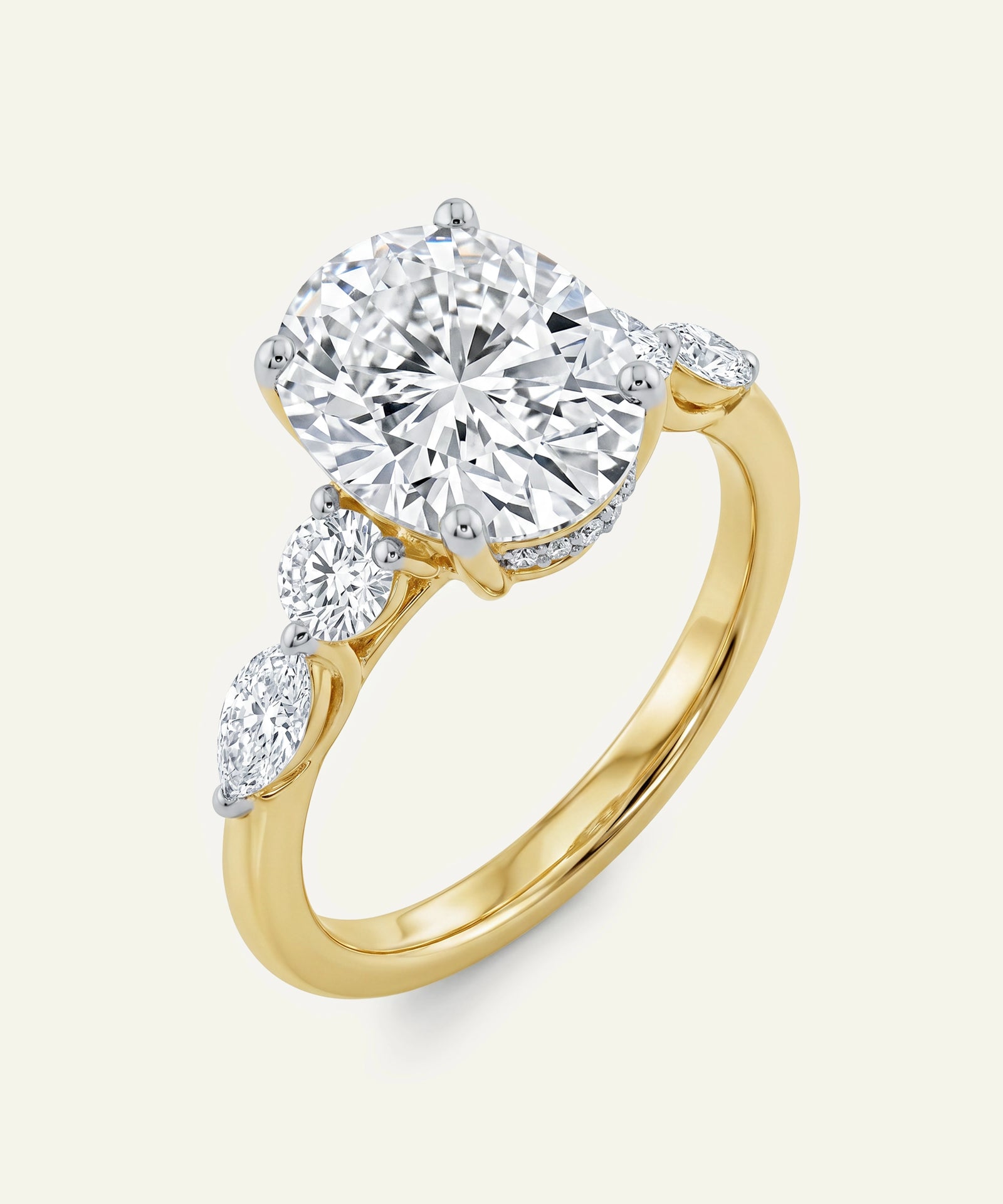 Gold ring with a large diamond and smaller diamonds on the band against a white background